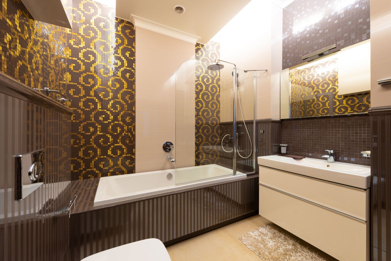 Bathroom with gold and brown mosaic tiles and a bathtub