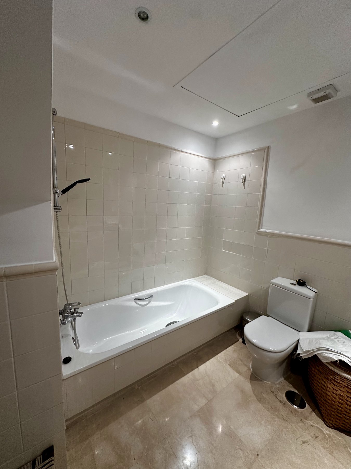 Bathroom before the renovation: a bathtub with beige tiles