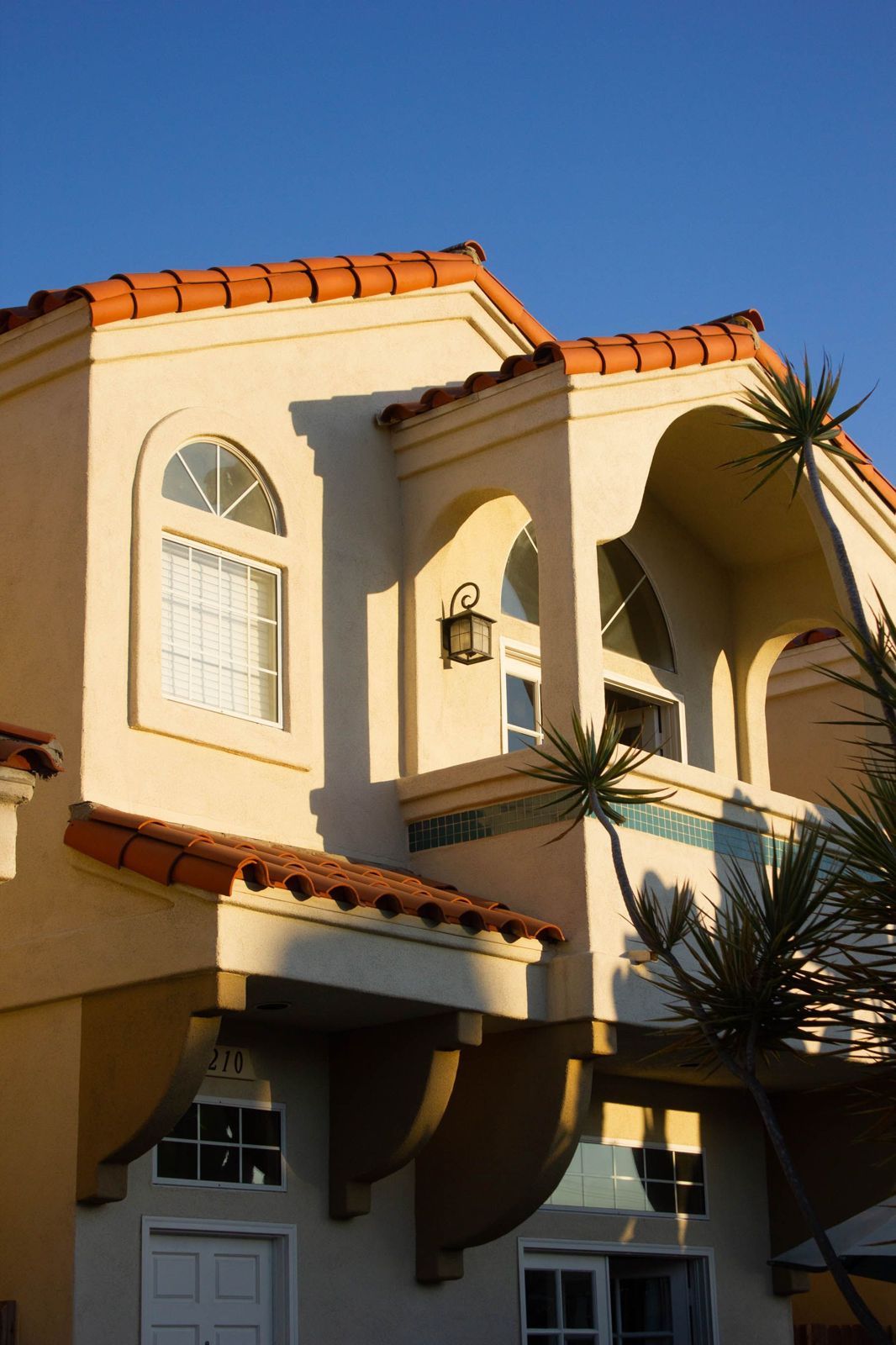 Mediterranean-style home with terracotta roof tiles in warm evening light